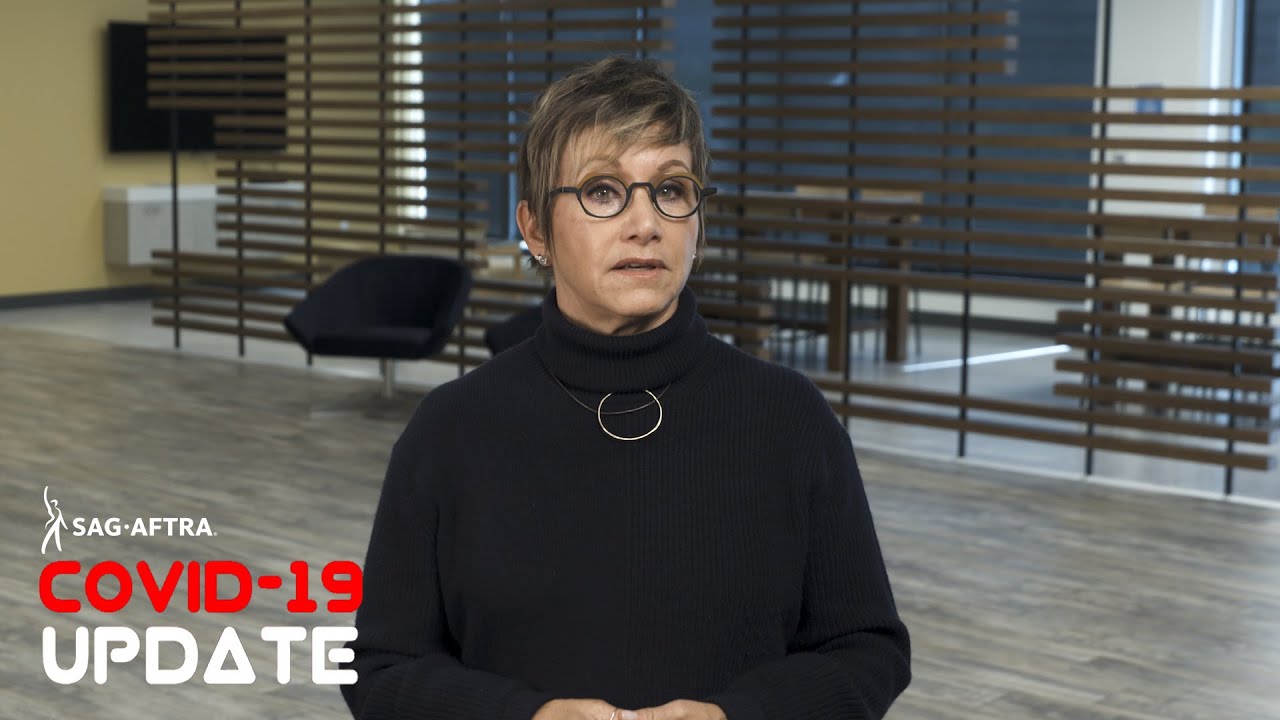 Carteris in black turtle neck wearing circle glasses looking into camera