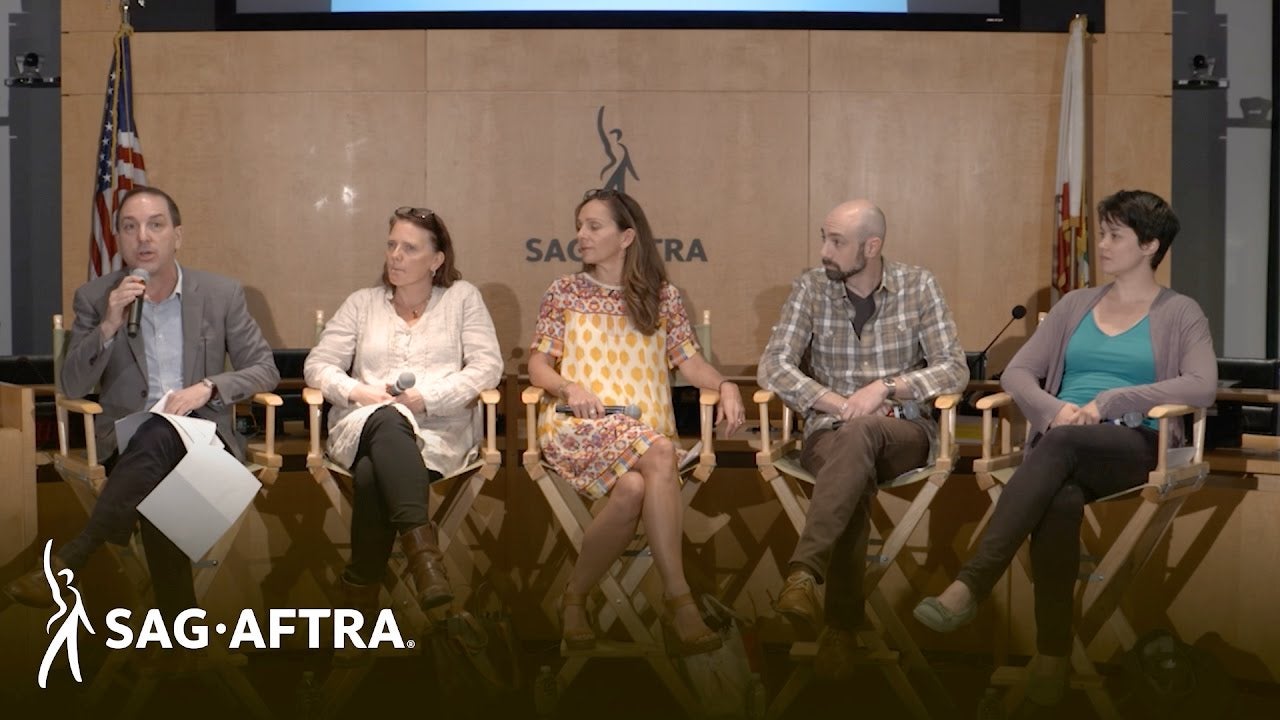Row of panelists smiling out at audience