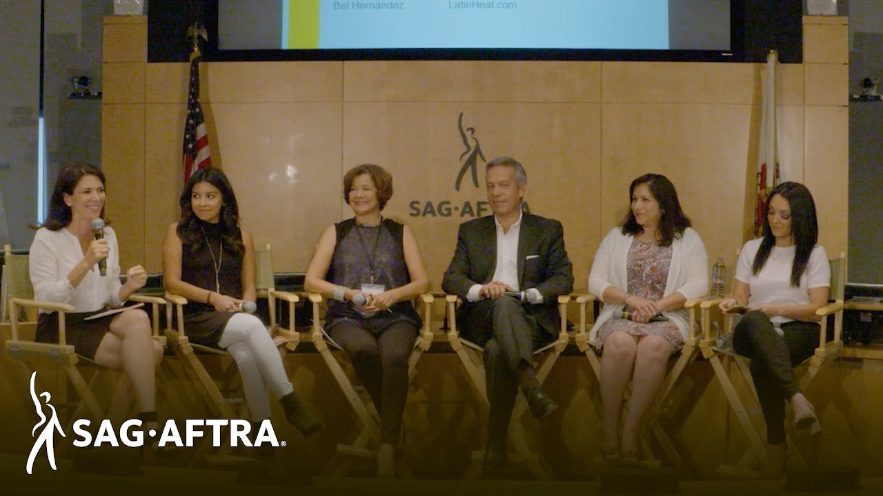 Row of panelists smiling out at audience