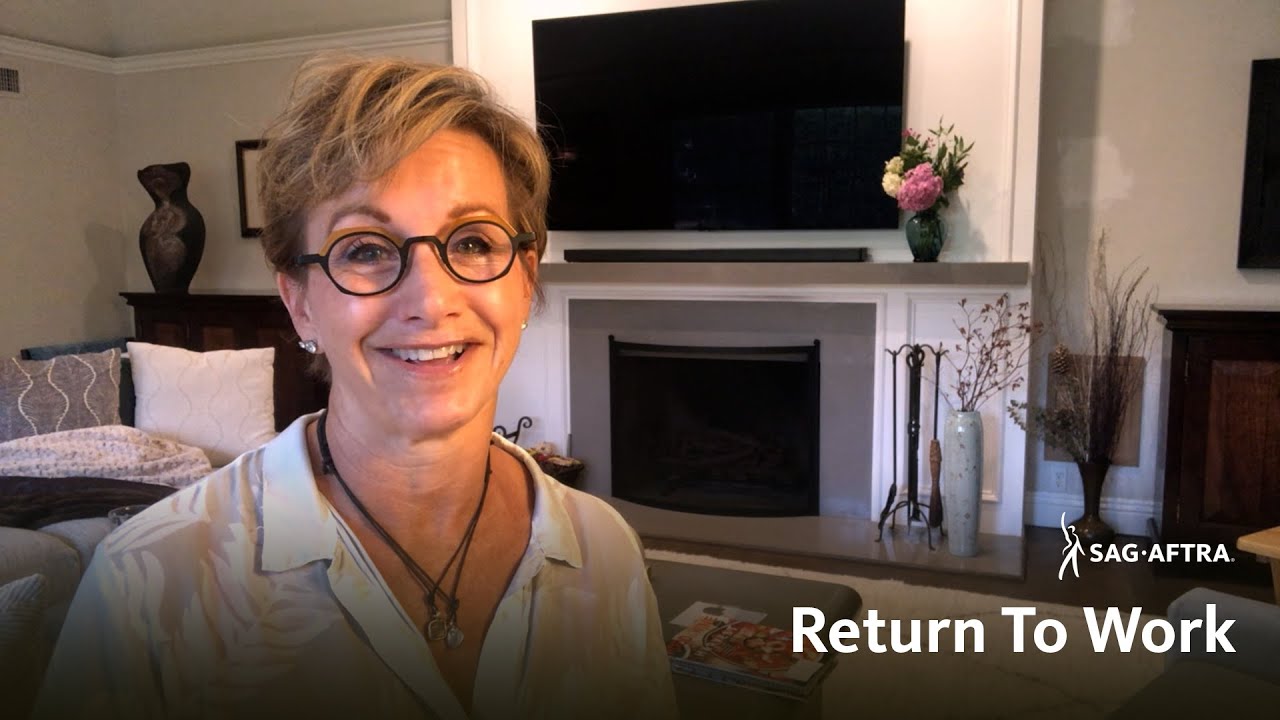 Carteris smiling at camera with a living room background