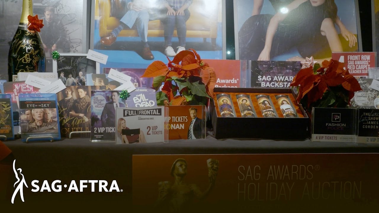 "Table of auction items including a large champagne bottle, VIP Tickets, Signed DVDs and more