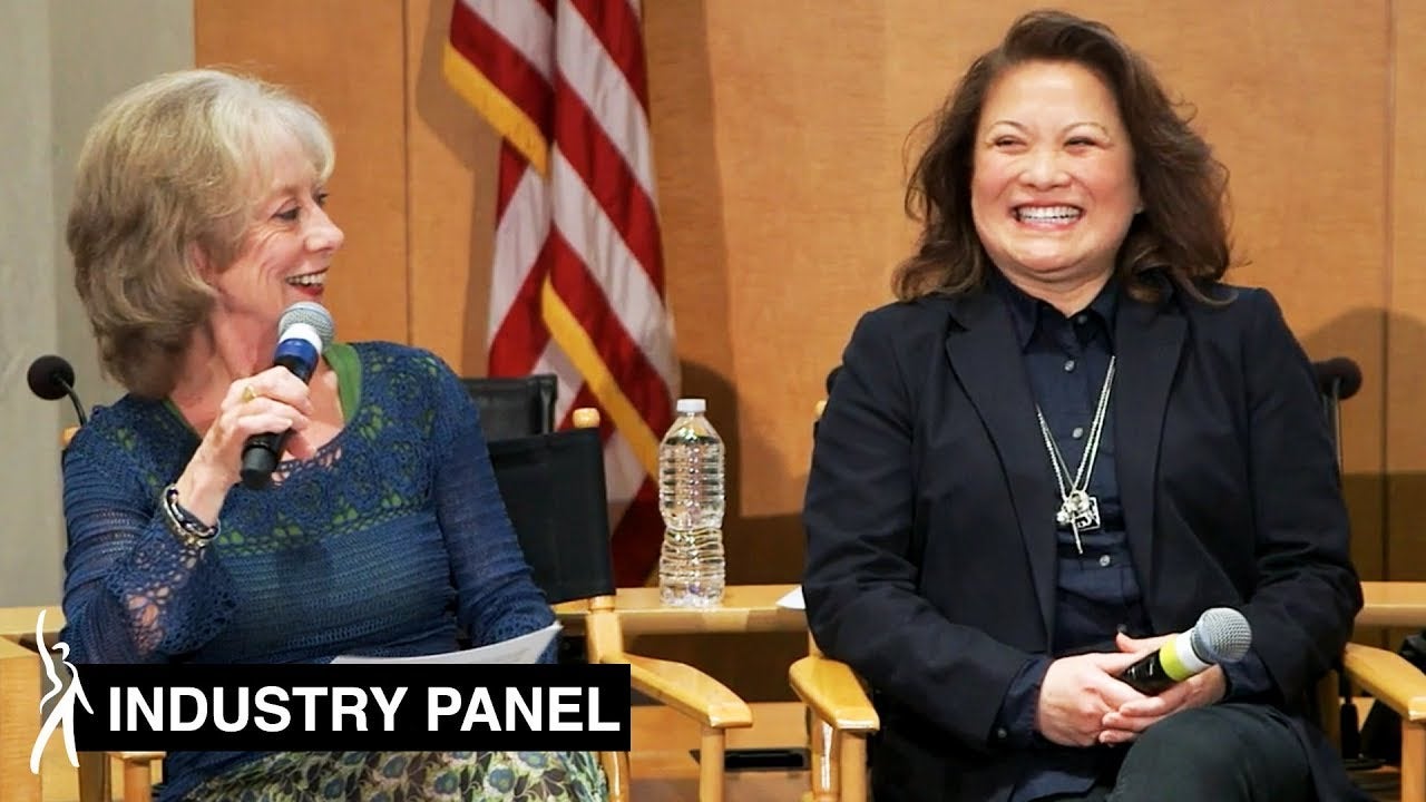 Crawford holding mic toward mouth looking at other panelists to her left.