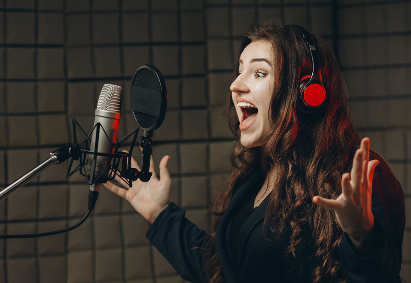 A voiceover actor speaks into a studio mic.
