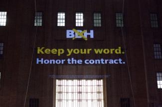 Projection on a building "BBH, Keep your word. Honor the contract."