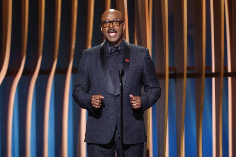 Vance wears an all-black suit on stage.  