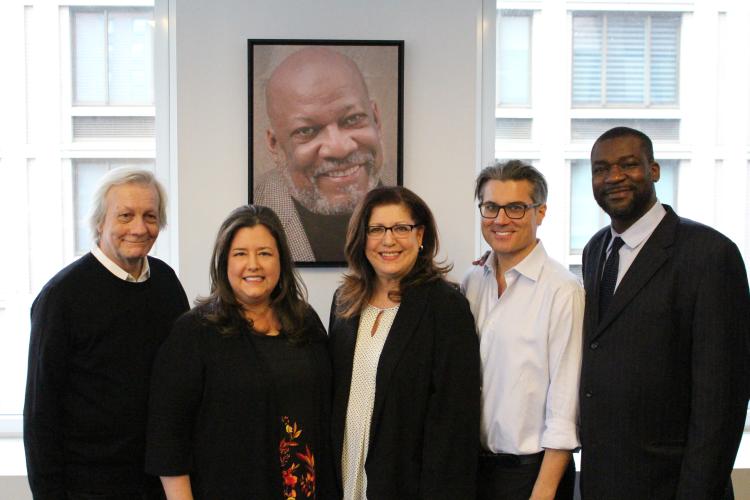 Everyone posing shoulder to should in front of Mike Hodge's photo.