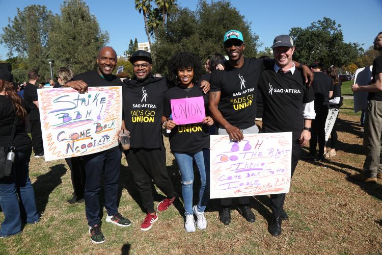 Members holding posters that read "Strike BBH! Come back, negotiate" and "BBH DO THE RIGHT THING. COME BACK TO THE TABLE. #StrikeBBH" wearing black SAG-AFTRA #AdsGoUnion t-shirts.
