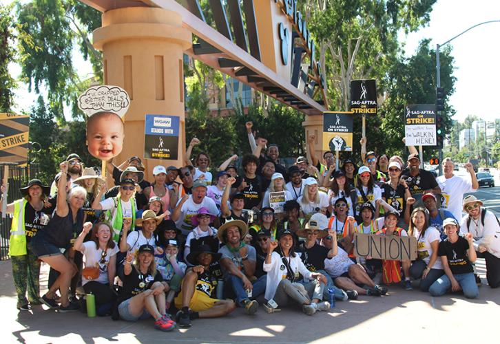 A crowd of picketers gather in front of the Disney Studios gate.