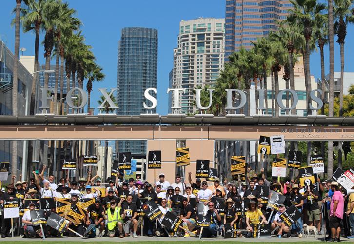 The crowd stands under the Fox Studios sign.