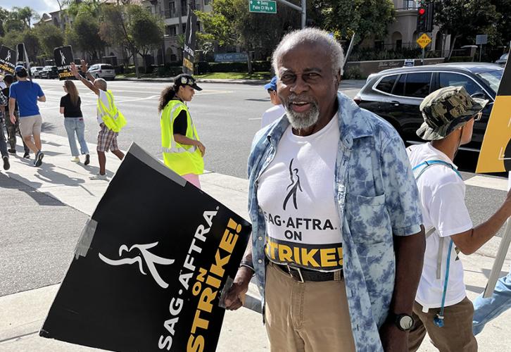 Jones stands on the street with a picket sign.