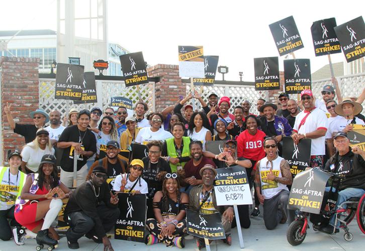 Members smile and pose with picket signs.