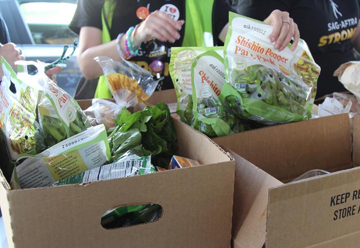 Cardboard boxes with bags of vegetables.