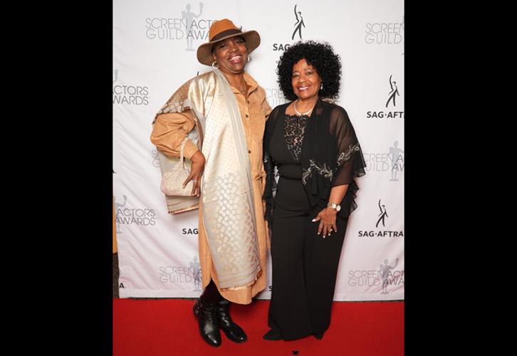 Two women smile on the red carpet.