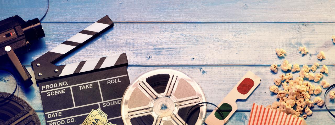 Film Canister, 3D glasses and clapperboard on a wooden blue table
