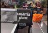 A candid photo of a ping pong table in a recreational space. On a small placard is “SAG-AFTRA & IATSE” written in all-cap white lettering, and beside it is a metal basket of orange ping pong balls.