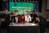 SAG-AFTRA and Mexican Actors Union ANDA Sign Cooperative Agreement at the 2019 National Convention DCI in suite next to Gabrielle Carteris leaning over a table, Ochoa pointing to the crowd with his righ thand, Treviño in white leaning over a table signing papers, Calva leaning over table in a black shirt and DW in a suite