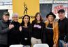 Local Board member Joe Corcoran, member Nancy Hall, Local Board member Sandy Kim, staff member Lisha Brock, member Marilyn Swick and Local Board member Jeff Unterkofler. Four women and two men in dark clothing stand in front of a yellow SAG-AFTRA banner.