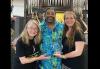 SF-NC Local President Kathryn Howell, left, SF-NC Local Assistant Executive Director Dee Dee Escobedo, right, and SF-NC Local member Vincent Dee Miles show the award the Local received from California Film Foundation for its long-standing partnership. Howell, Escobedo and Miles pose playfully in front of a pipe organ. Miles wears a Hawaiian shirt and the others are dressed in black.