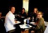 Acting in Plain Sight | SAG-AFTRA Podcast David white sitting at a table with headphones wearing a white button up smiling sitting next to Carteris in a olive Cardigan and headset. Bender and Harcharic sit side by side and across the table from White with headphones on.