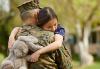Dressed Military personnel carrying a young girl whose arms are wrapped around Military personnel holding a light grey stuffed bunny  