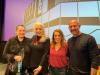 From left, casting director Suzanne Goddard-Smythe, SAG-AFTRA L.A. Local Conservatory Committee member Lee Garlington and casting directors Sandi Logan and Seth Yanklewitz at L.A. Film School after a Conservatory panel on the landscape of casting directing. Goddard-Smythe wears all black and holds a water bottle. She has an arm around Lee Garlington, who is dressed in black with a red necklace. Logan wears a pink floral blouse and blue denim jeans, and has her arms around Garlington and Yanklewitz, who is wearing a black shirt. There is a screen behind them that is purple with a black and white architectural design.