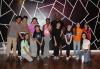 L.A. Local young performers and Looking Ahead staff pose for a photo after a movement class with SAG-AFTRA member Alyson Stoner, middle, hosted by the Entertainment Community Fund’s Looking Ahead program. A group of individuals pose in front of a black wall with white geometric lines.