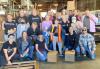 L.A. Local SAG-AFTRA members volunteer at the Labor Community Services warehouse packing food boxes for distribution sites. A group of individuals huddle together in a warehouse with boxes around them.