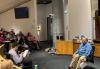 SAG-AFTRA member Michael D. Cohen observes and critiques a scene during Creating Characters for TV/Film, a class held at SAG-AFTRA Plaza on Feb. 5. Two individuals sit in chairs acting out a scene with another individual sitting in a chair looking on, in front of an audience of people.