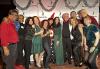 A large group of SAG-AFTRA New England members pose in front of a festive backdrop at the holiday party on Dec. 16. A diverse group of 13 SAG-AFTRA New England members pose for a photo in front of a SAG-AFTRA step-and-repeat decorated with a silver garland. Some sport holiday colors and hats.