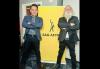 San Diego Local member Matt Amar and San Diego Local President Larry Poole at the Dec. 5 membership meeting. Photos by Matt Amar. Two people in suits stand with their arms folded on either side of a yellow SAG-AFTRA banner.